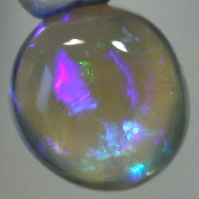 SOLID CRYSTAL OPAL High dome with blue and purple hues throughout the transparent body